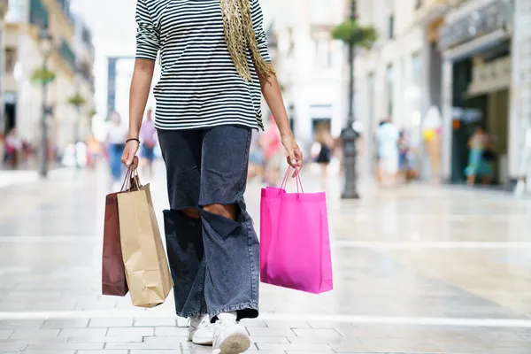 Femme méconnaissable avec des sacs à provisions dans la rue. — Photo