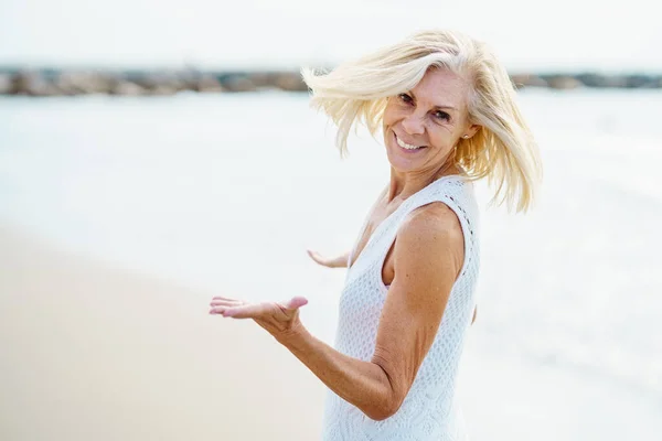 Gelukkig volwassen vrouw wandelen op het strand, besteden haar vrije tijd, genieten van haar vrije tijd — Stockfoto