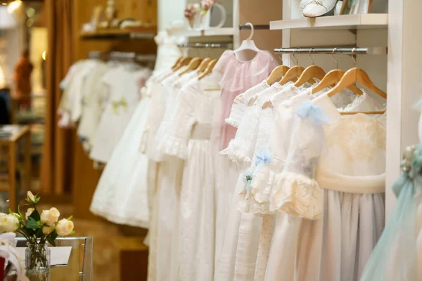 Expositor con vestidos de primera comunión para niñas en una lujosa tienda de ropa infantil. — Foto de Stock