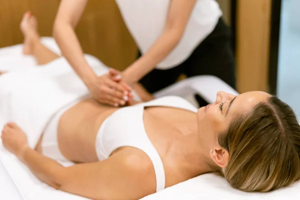 Жінка середнього віку має масаж живота в салоні краси . — стокове фото