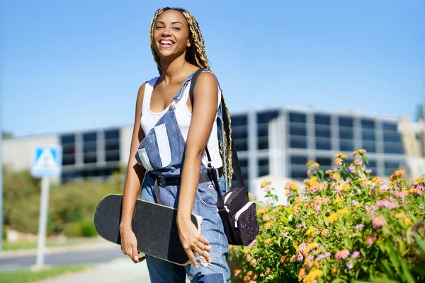 Schwarze Frau lächelnd mit farbigen Zöpfen. Typisch afrikanische Frisur. — Stockfoto