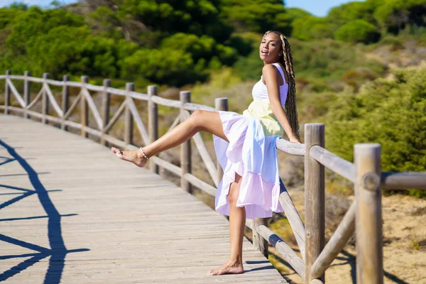 Afrikanerin in einem schönen Kleid auf der Strandpromenade. — Stockfoto