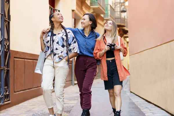 Gelukkige multiraciale vrouwelijke beste vrienden wandelen in de stad tijdens vakantie — Stockfoto