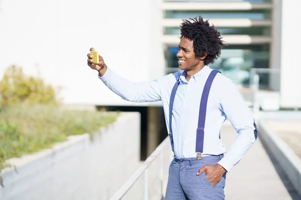 Uomo d'affari nero che si fa selfie con uno smartphone in città — Foto Stock