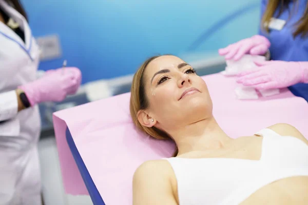 Žena středního věku ležící na nosítkách na estetické klinice. — Stock fotografie