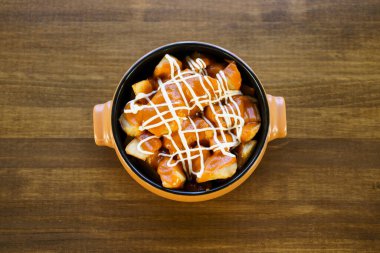 Restoran masasında tipik bir İspanyol yemeği olan patatas bravas tabağı.
