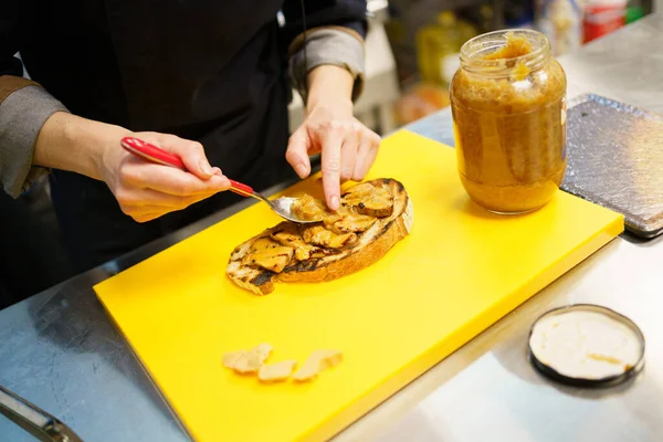 Шеф кладет кусочки фуа на кусок жареного хлеба — стоковое фото