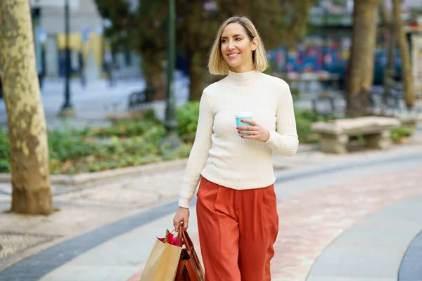 Mujer sonriente con bolsa de papel para llevar de café para llevar — Foto de Stock