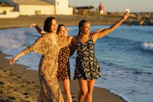 三个穿着夏装笑着在海滩上一起玩乐的多民族小女孩. — 图库照片