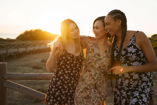 Vreugdevolle multi-etnische vrouwen omhelzing in de buurt hek — Stockfoto