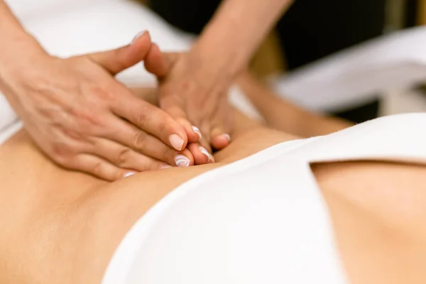Жінка середнього віку має масаж живота в салоні краси . — стокове фото