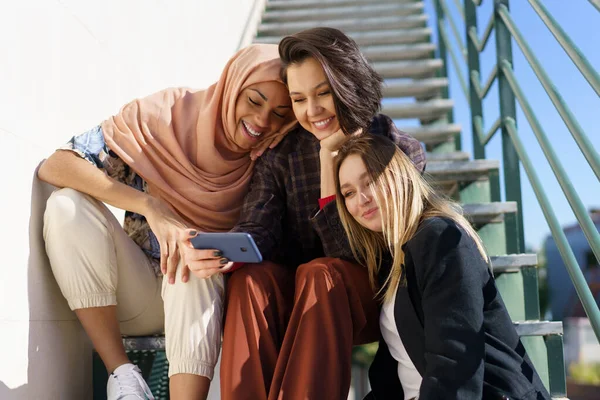 Gesellschaft lächelnder Frauen, die auf der Treppe sitzen und reden — Stockfoto
