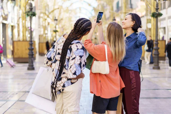 Snygg varierad kvinnor står på gatan och tar foto — Stockfoto