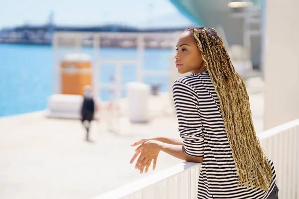 Joven mujer negra disfrutando de la vista del puerto. — Foto de Stock