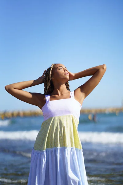 Schwarze Frau läuft am Strand entlang und trägt ein schönes langes Kleid. — Stockfoto