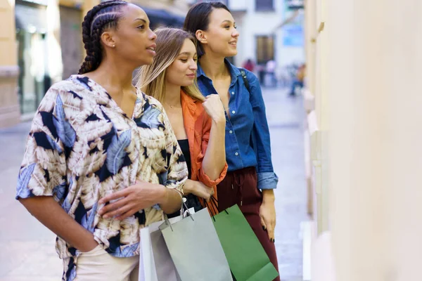 Mujeres multiétnicas de pie cerca del escaparate —  Fotos de Stock