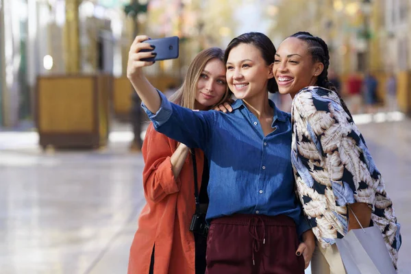 Mujeres sonrientes y multirraciales tomando selfie en la ciudad —  Fotos de Stock