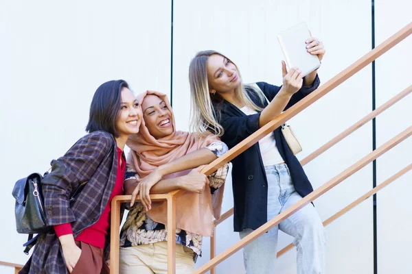 Jeunes milléniaux féminins multiethniques excités souriants et prenant du selfie sur tablette — Photo