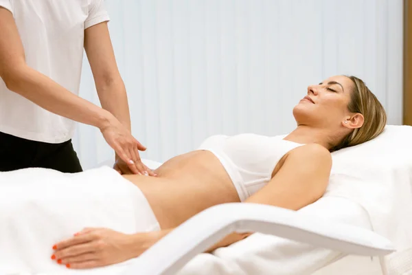 Middle-aged woman having a belly massage in a beauty salon. — Stock Photo, Image