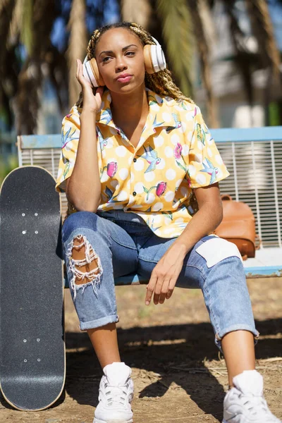 Afro-Amerikaanse vrouwelijke schaatser luisteren naar muziek — Stockfoto