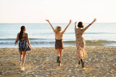 Denize doğru yürüyen yüzsüz kız arkadaşlar