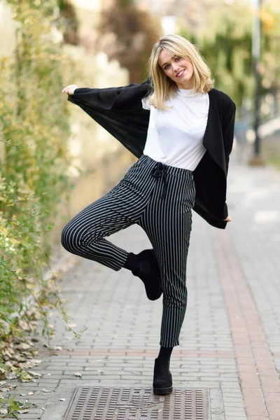 Mulher loira jovem bonita em fundo urbano — Fotografia de Stock