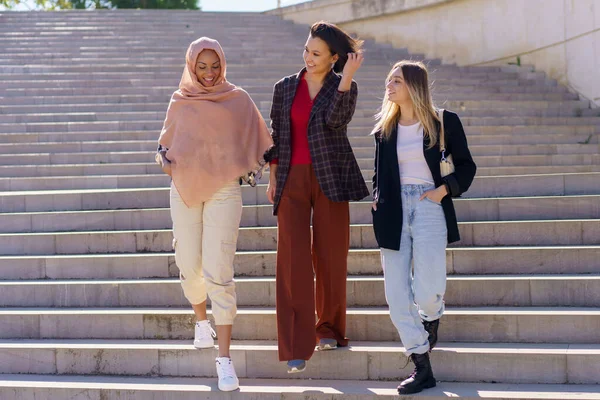 Jóvenes positivos diversas mujeres amigas caminando abajo en el campus — Foto de Stock