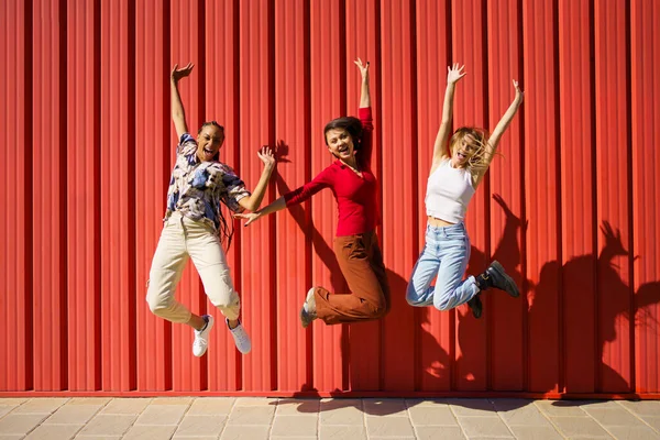 Excited multiethnic women jumping on street — Foto Stock