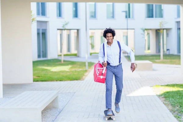 Positivo uomo d'affari nero guida skateboard in città — Foto Stock