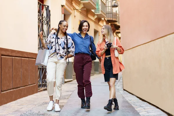 Cheerful diverse women with photo camera near building —  Fotos de Stock