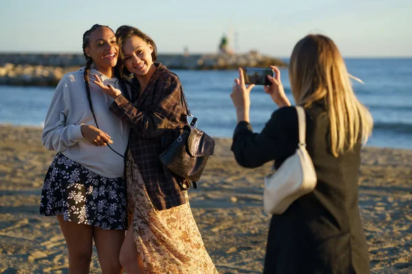 没有脸的女人在海滨给快乐的不同女友拍照 — 图库照片