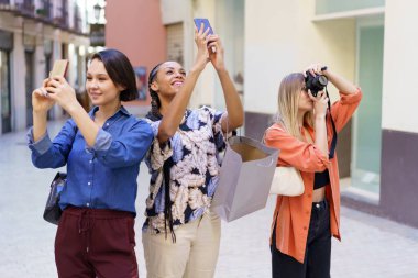 Şehrin fotoğraflarını çeken çok çeşitli kadınlar var.