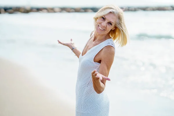 Mosolygó érett nő sétál a parton, tölti szabadidejét, élvezi a szabadidejét — Stock Fotó