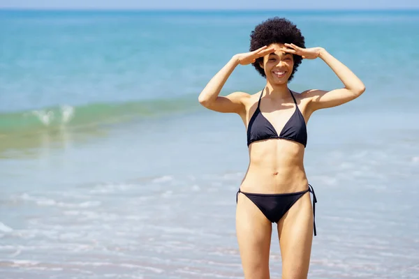 Positieve zwarte vrouw maakt een grappig gebaar van het zetten van een bril met haar handen. — Stockfoto