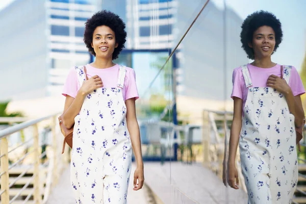 Glada Afroamerikanska Kvinna Casual Kläder Promenader Mellan Moderna Byggnader Ler — Stockfoto