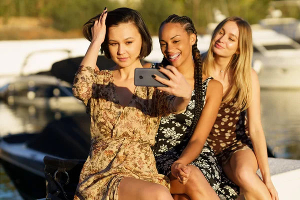 Grupo Encantadas Amigas Multirraciales Tomando Selfie Teléfono Inteligente Mientras Sientan —  Fotos de Stock