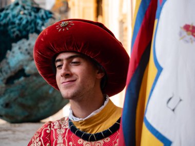 Siena, İtalya - 15 Ağustos 2021: Standart Salyangoz Taşıyıcısı, Contrada della Chiocciola bayrağı taşıyan ve 15. yüzyıl kostümleri giyen bir Sayfa..