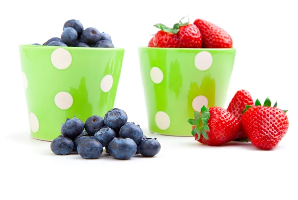 Assorted fresh picked berries in a green mug over a white backgr — Stock Photo, Image