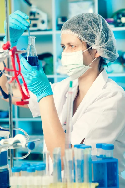 Wetenschappelijk onderzoeker bij een vloeibare oplossing in een lab — Stockfoto