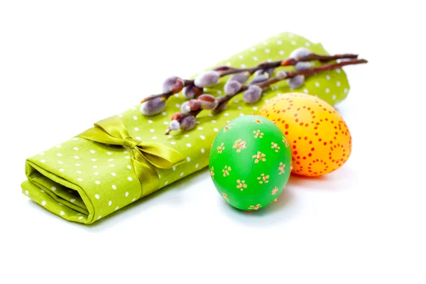 Two painted easter eggs with pussy-willow on green serviette, isolated on white background. — Stock Photo, Image