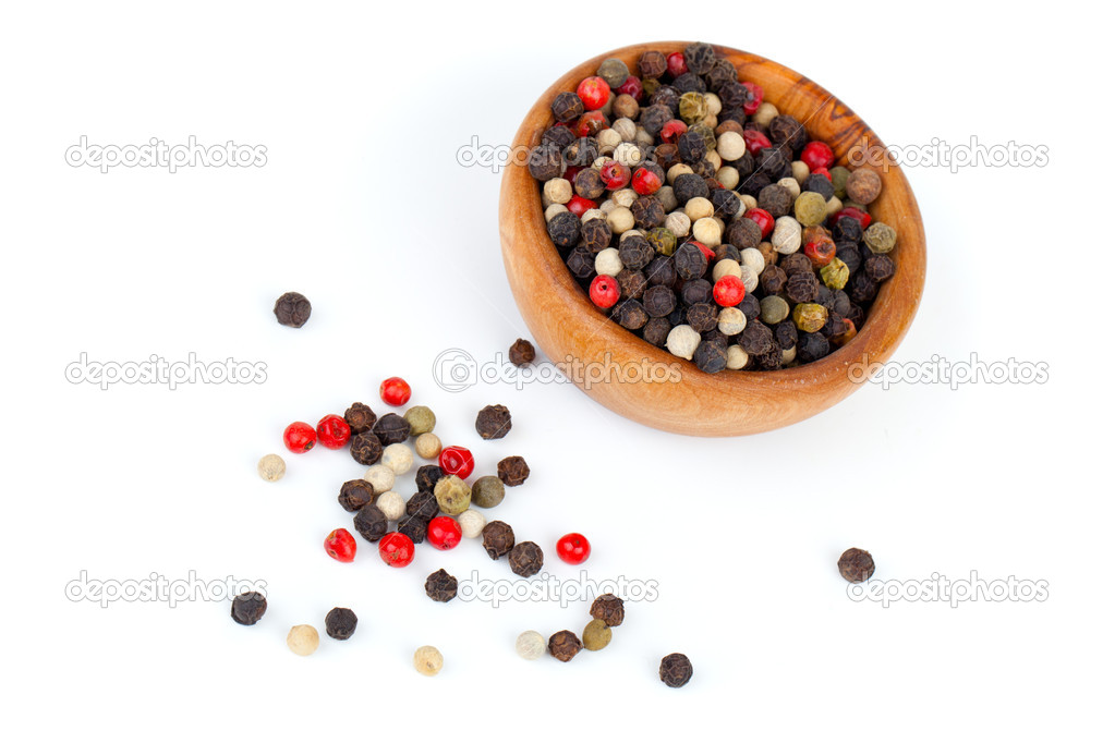 Coloured pepper on a wooden bowl, isolated on white