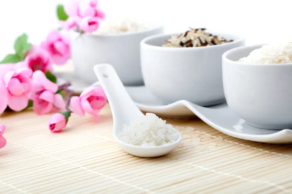 Uncooked rice with porcelain bowls — Stock Photo, Image