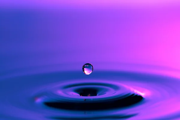 Water drop falling to a liquid surface — Stock Photo, Image