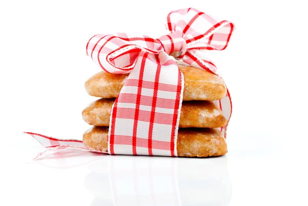 Печиво-сердечка, з'єднані червоною стрічкою на білому тлі — стокове фото