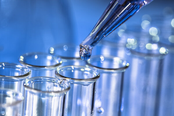 Pipette adding fluid to one of several test tubes