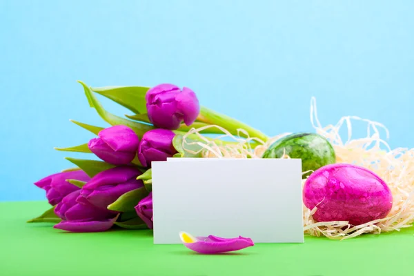 Bouquet of tulips with blank card and Easter eggs — Stock Photo, Image