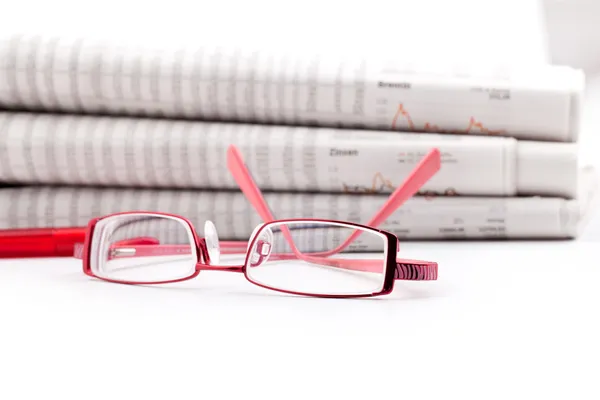 Gafas de lectura se encuentran ante una gran pila de periódicos — Foto de Stock