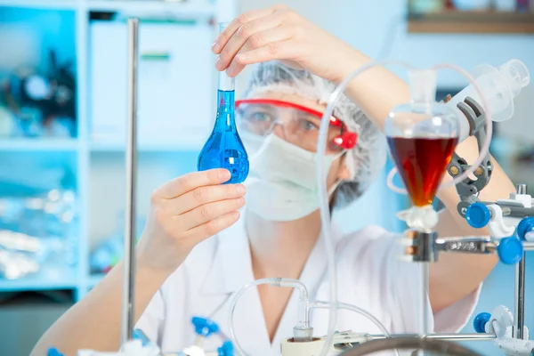 Investigador científico sosteniendo una solución líquida en un laboratorio — Foto de Stock