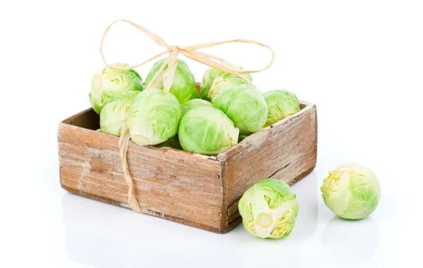 Fresh green brussels sprouts in the wooden box, on a white backg — Stock Photo, Image