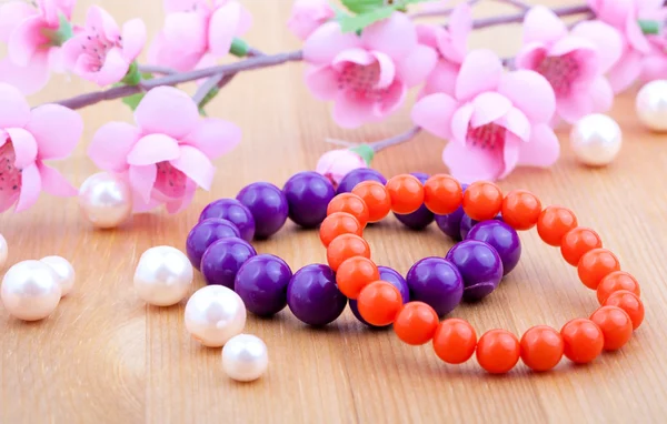 Multi color coral bangles and artificial pearls, with pink flowe — Stock Photo, Image